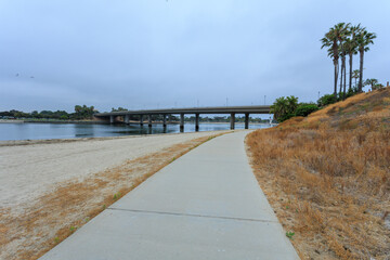 Bayside walk along Fishermans Channel near Ingraham Street Bridge and Vacation Isle in morning hours under cloudy sky, San Diego, San Diego, California