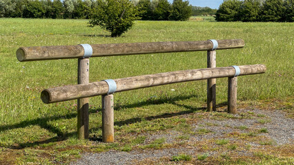A rustic wooden obstacle for an outdoor fitness, workout, or parkour training course in a public park