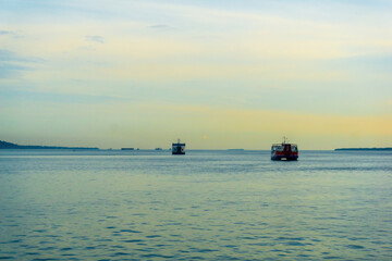 Obraz premium A ferry crosses the vibrant, blue Bali Strait under a sunny sky