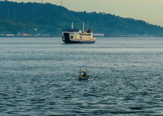 A ferry crosses the vibrant, blue Bali Strait under a sunny sky