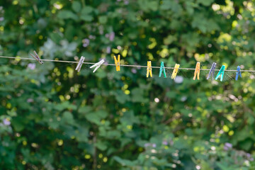 Old spiderweb covered pegs hanging on weathered outdoor clothesline