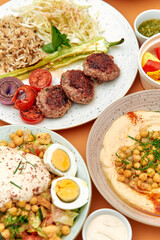 A Vibrant Spread of Mediterranean Cuisine Featuring Lentils, Grains, Fresh Vegetables, and Grilled Meats Plated in Colorful Dishes for a Nourishing Meal