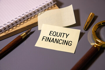Equity financing is written on paper. Keyboard and calculator on the table