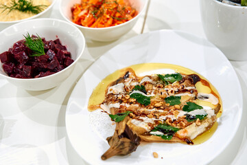A Deliciously Plated Eggplant Dish Garnished with Nuts, Herbs, and a Rich Oil Drizzle, Accompanied...