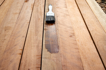 Varnish paint work in wood construction project using a paint brush tool. Chemical product to improve appearance, protection and coat wood grain for prevention woodworm, termite, and fungus.