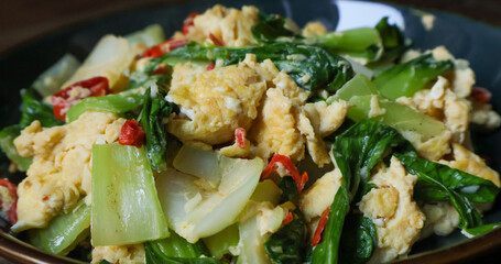 Stir-fried bok choy or pak choy with scrambled eggs, showcasing vibrant green and golden colors. Healthy cooking, Asian cuisine, food blogs, and recipe illustrations. Close up