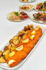 A Vibrant Selection of Delicious Fried Fish Fillets Served with Golden Potatoes and Fresh Lemon...