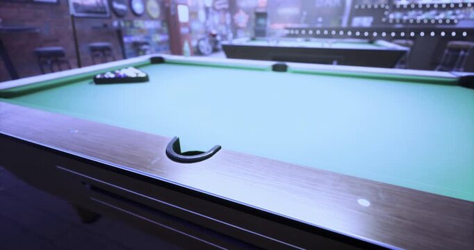 Players eagerly prepare for a game of billiards in a warm, welcoming bar. The atmosphere is lively, filled with anticipation, laughter, and the soft clinks of pool balls.