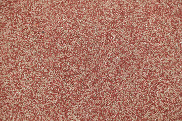 A texture background of red soft rubber safety flooring from a playground or running track