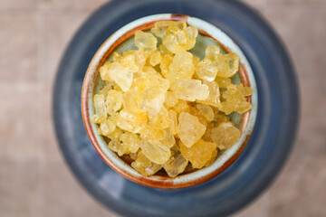Close up view of yellow crystal rock sugar in a bowl. Also known as gula batu 