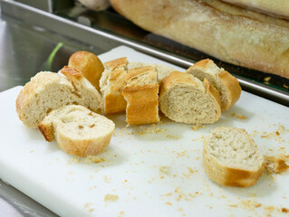 Freshly baked bread sliced invitingly on a clean chopping board in a sunlit kitchen during a cozy...