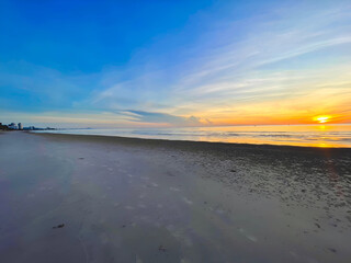 Empty beach at sunrise with soft colors and golden horizon