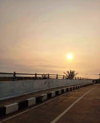 A peaceful and beautiful sunrise illuminates the morning sky, casting a warm golden glow over a...