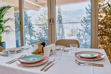 Elegant dining setup with stylish tableware, showcasing a serene view of nature, perfect for a memorable meal or special occasion.