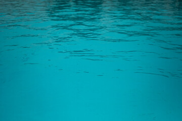 Blue clear water in a filled swimming pool surface texture reflection