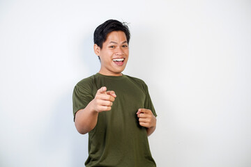 A smiling young Asian man wearing a green shirt pointing forward	