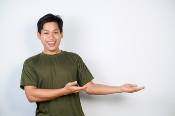 Portrait of a cheerful man in green pointing amiably to blank space, ideal for presentations,...