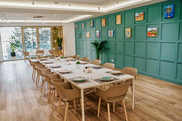 A Beautifully Set Dining Table in an Elegantly Designed Space Featuring Green Walls, Artistic Decor, and a Bright, Inviting Atmosphere for Memorable Gatherings