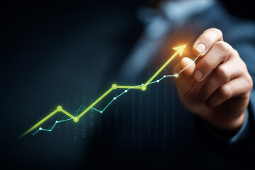 Businessman holding a rising graph arrow and a growing stock market chart with green arrows pointing up on a virtual screen, 