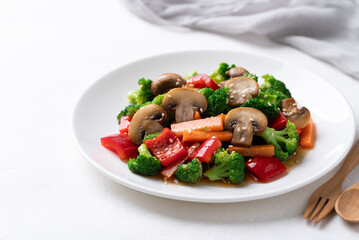 Stir fried vegetables, champignon mushroom, broccoli, bell pepper and carrot with soy sauce, Asian vegetarian food, Healthy eating