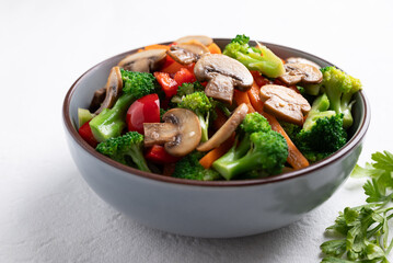 Stir fried vegetables, champignon mushroom, broccoli, bell pepper and carrot with soy sauce, Asian vegetarian food, Healthy eating