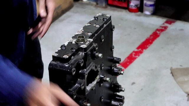 Mechanic is dismantling the automatic allison transmission control valve for inspection and repair. 