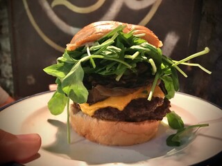 Delicious burger with arugula, caramelized onions, and melted cheese being served in buenos aires...