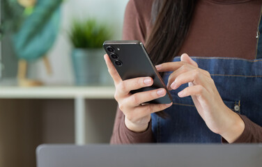 Digital Communication. Woman using smartphone in a plant shop.