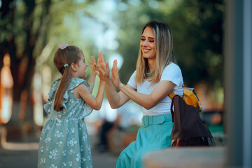 Mother and Daughter Playing Hand Clapping Game Together. Cheerful mom and little girl having fun...