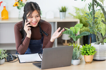 Remote Work. Young woman engaging in a video call while managing a plant shop.