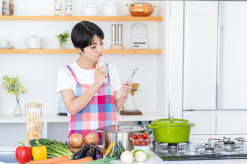 野菜をみながら、レシピを探す主婦。