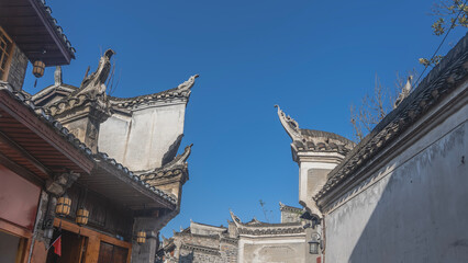 Details of Chinese architecture. Roofs of buildings with curved eaves against the blue sky. Carved...