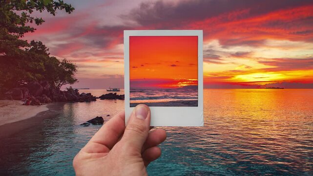 Tropical island beach sunset time lapse inside polaroid frame, held by hand, cinemagraph video loop - Powered by Adobe