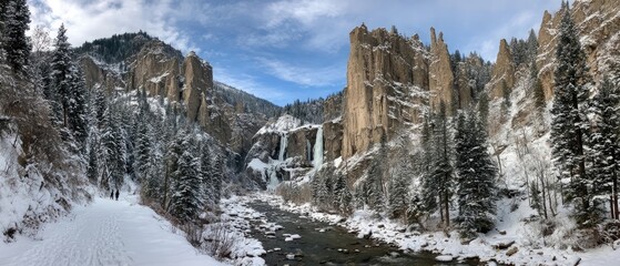 Snowy winter landscape with a waterfall cascading through a canyon