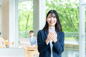 オフィスでスマホを使うビジネスウーマン