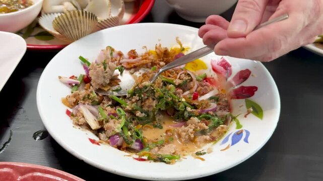 Serving Spicy Minced Pork Salad in Thai Restaurant Setting