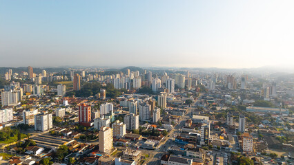Fototapeta premium Aerial cityscape of Joinville, Santa Catarina, Brazil, featuring tall buildings and urban sprawl under clear skies.