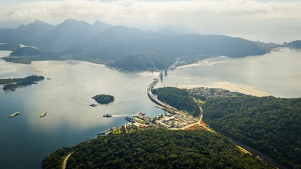 Aerial view of Guaratuba Bay with ferry crossing, bridge construction.
