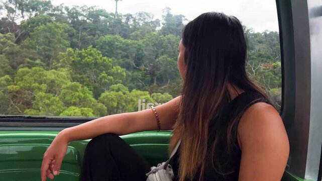 Asian Woman Riding Skyrail Through Australia's Wet Tropics Rainforest