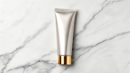 Silver cosmetic cream tube with gold cap on a white marble background, representing luxury skincare and beauty products
