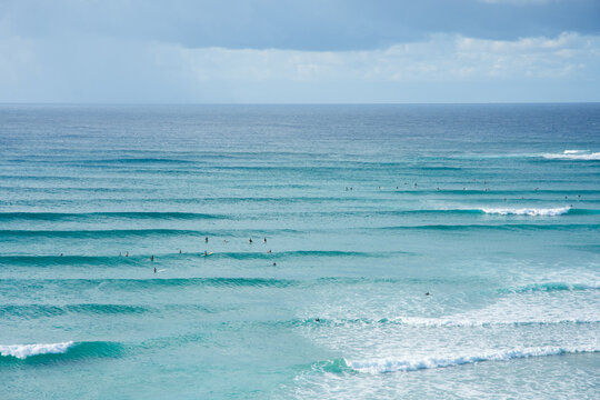 An aerial view of surfers waiting for a wave in the ocean