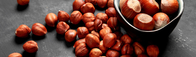 Organic hazelnut in bowl on dark grey