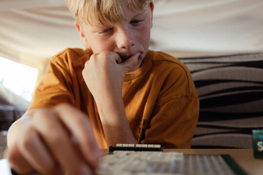 Young teenager thinking deeply about board game