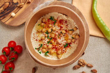 A Traditional Dish with Chickpeas and Spices Served in a Rustic Bowl, Garnished with Fresh Herbs and Accompanied by Tomato and Green Chili