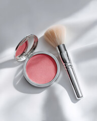 Minimalist overhead shot of single blush compact alongside soft brush, showcasing delicate pink hue. composition highlights beauty and elegance, perfect for makeup enthusiasts