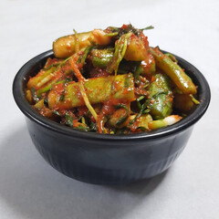 A close-up of a container of cucumber kimchi (oi-sobagi), a spicy and refreshing Korean side dish.