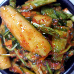 A close-up of a container of cucumber kimchi (oi-sobagi), a spicy and refreshing Korean side dish.