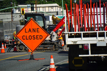 Lane closed sign with road work being done