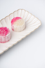Homemade Chinese snow skin mooncakes. Snowy Moon cakes on a White Background. Mid-Autumn Festival, traditional Asian desserts, and seasonal celebrations in Asian countries