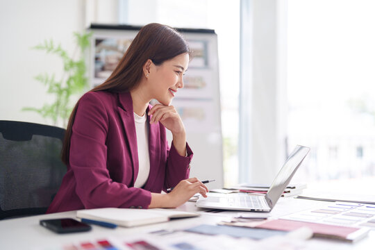 Asian adult woman business professional architect designer creates plans uses laptop modern office environment strategic project development